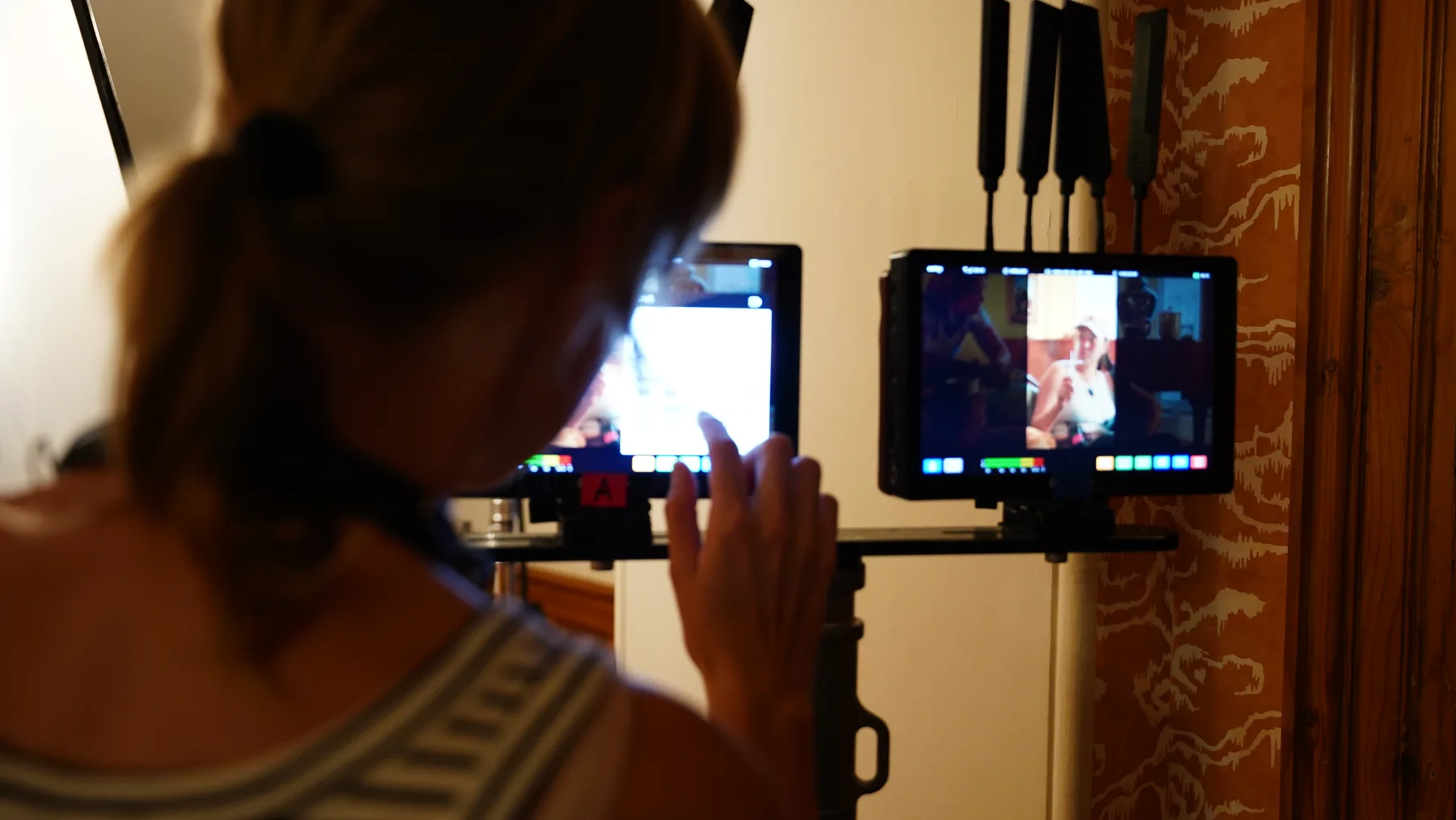 Crew member checking Murder at Macintosh Manor production monitors indoors