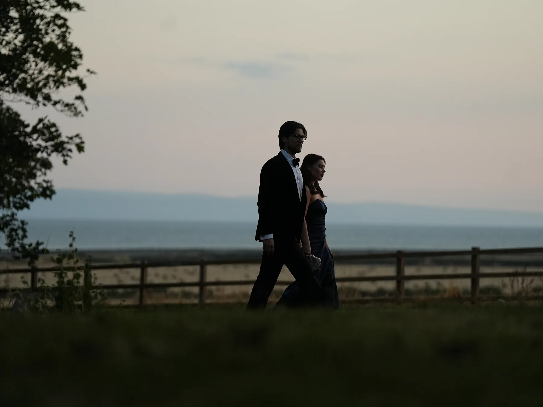 Cast members in formal wear walking beside the coast