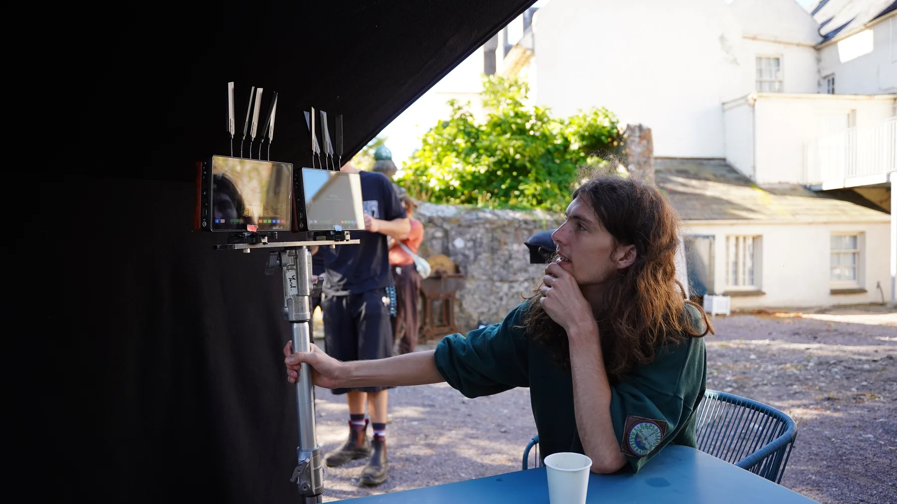 Crew member reviews the production monitors outside the manor