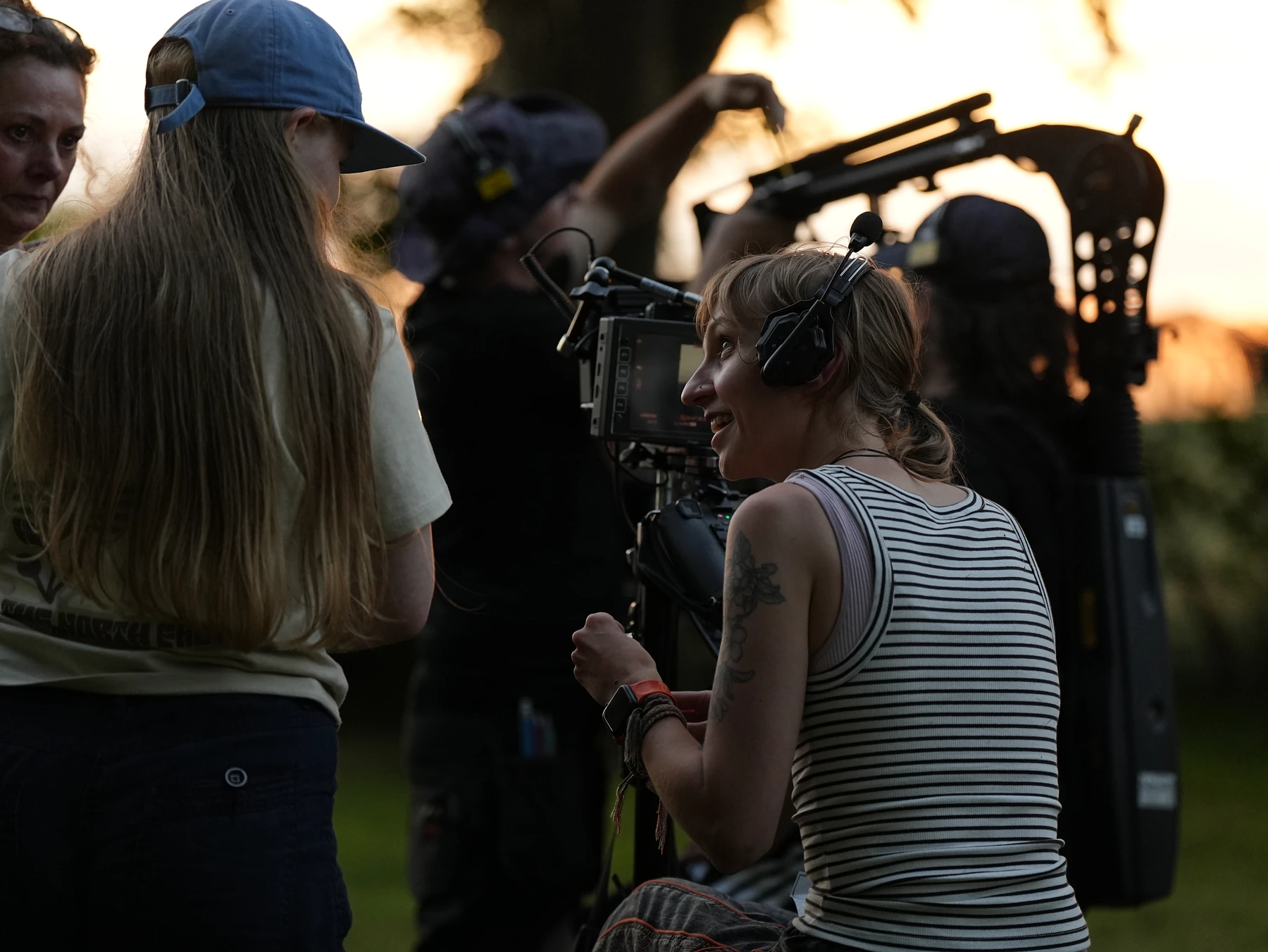 Crew members collaborating around a camera rig on location at sunset