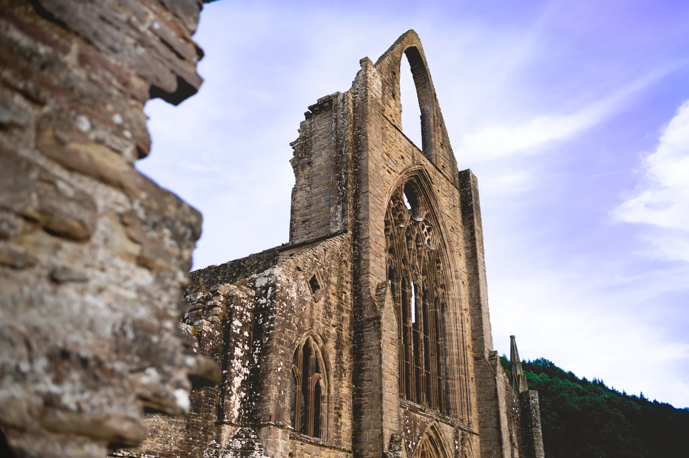 Historic stone ruins and a tall arched window beneath a blue sky